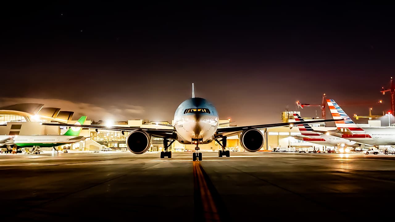 An aircraft approaches the runway at Los Angeles International Airport at night, framed by airfield and terminal lights. Photo courtesy Los Angeles World Airports / Jacob Brosseau.